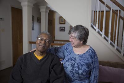 Two clients smile, one looks at the camera while the other looks at their friend