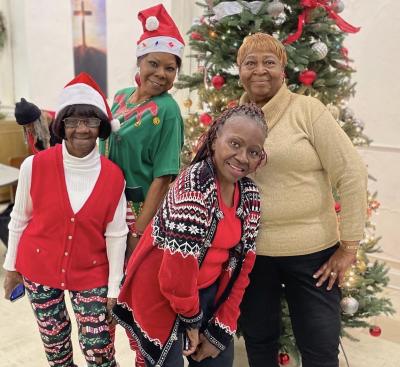 Friendship Cafe clients smile around the Christmas tree